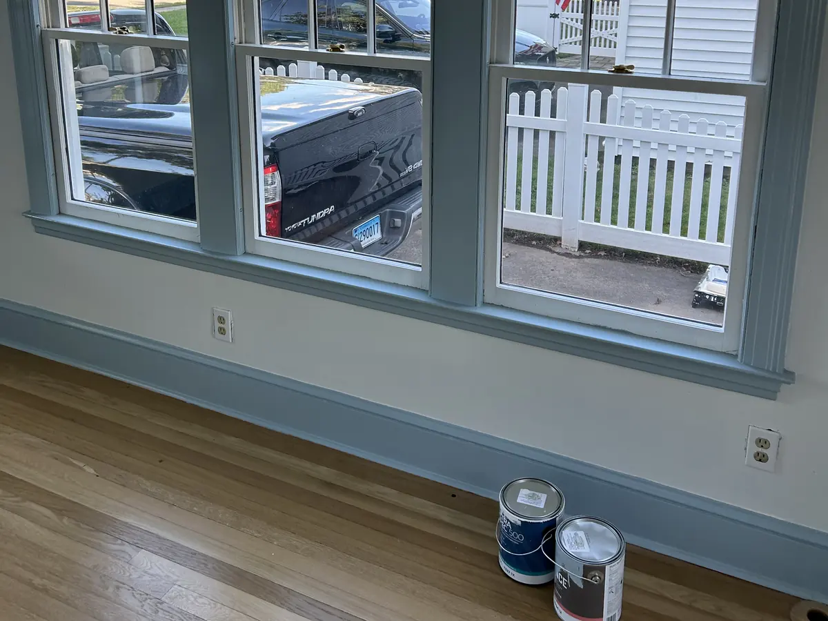Paint cans on the floor beneath freshly painted window trim during a Central Connecticut color consultation