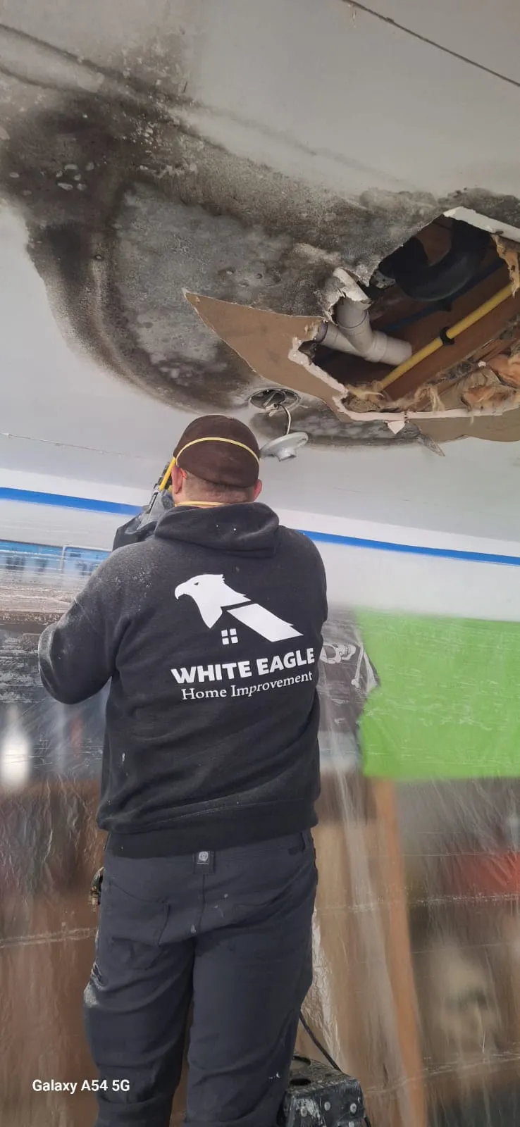 White Eagle crew member in front of a completed exterior repaint